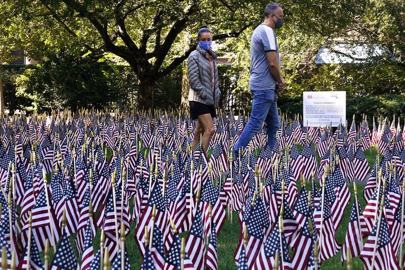 Et par i Boston går fredag ​​gjennom et felt med nesten 3000 flagg, som hver representerer en person som døde i angrepet på World Trade Center 11. september 2001.