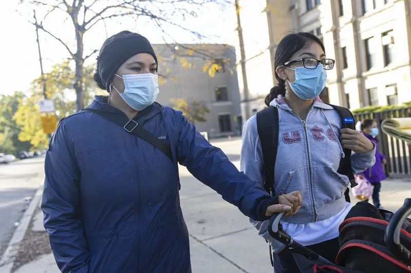 Maria Davila (stânga), mama a patru elevi de la Eberhart Elementary School din Marquette Park. Fiica ei Giselle Torres (dreapta) și unul dintre fiii ei mai mici s-au plâns de băile școlii.