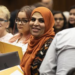 36 metų Jordanijoje gimusi Sabra Isa (viduryje) šypsosi savo šeimai, davusi ištikimybės priesaiką per natūralizacijos ceremoniją, siekdama užbaigti tapti JAV piliečiu, Dirkseno federaliniame teismo rūmuose, antradienį, liepos 2 d. 2019 m.