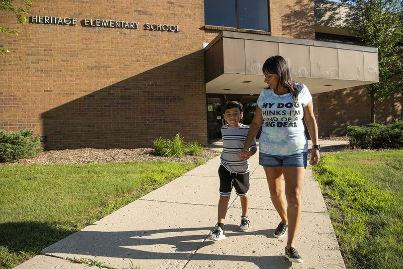 Jeremiah Wells (5), izquierda, camina con su madre Diana Martinez frente a la escuela primaria Heritage, el martes 28 de julio de 2020, en Streamwood Ill. Jeremiah comenzará el jardín de infantes en Heritage el próximo otoño a través de clases en línea. | Tyler LaRiviere / Sun-Times