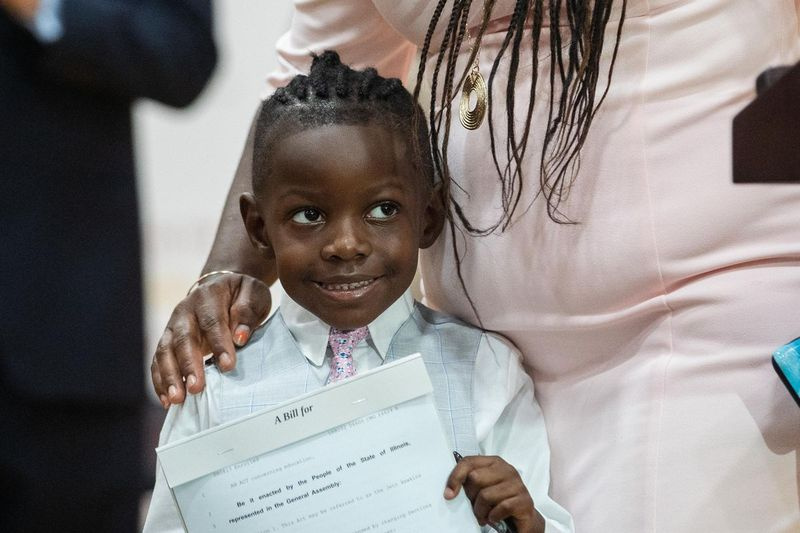 Jett Hawkins deține vineri proiectul de lege care tocmai a fost semnat de guvernatorul J.B. Pritzker la Uplift Community High School din cartierul Uptown.