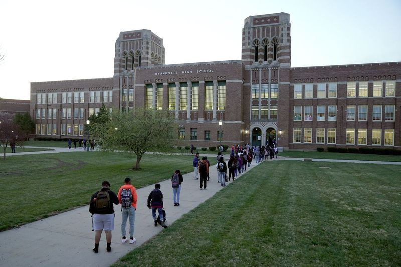 V túto stredu, 31. marca 2021, na archívnej fotografii, študenti čakajú na vstup do Wyandotte County High School v Kansas City, Kan., v prvý deň osobného učenia. Konzervatívni zákonodarcovia GOP v Kansase presadzujú návrh, ktorý by rodičom umožnil použiť štátne doláre na zaplatenie súkromného vzdelávania pre deti, ktoré majú problémy na verejných školách.