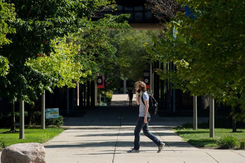 O persoană care poartă o mască se plimbă prin campusul Universității din Illinois din Chicago vineri după-amiază, 14 august 2020. | Pat Nabong/Sun-Times
