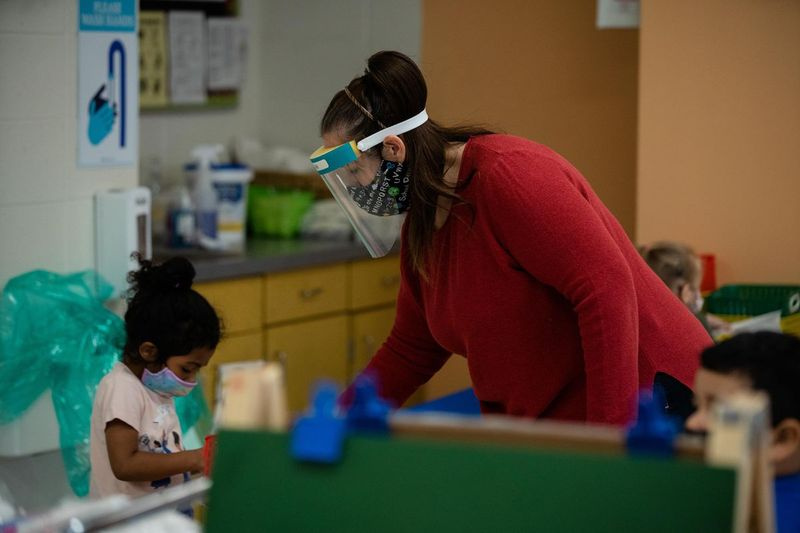 Ein Lehrer unterstützte letzten Monat einen Schüler während einer Vorschulklasse an der Jordan Community Elementary School. nach der vorübergehenden Wiedereröffnung der Schulen für das persönliche Lernen.
