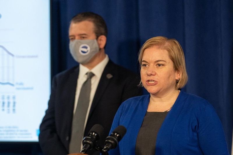 Komisarka čikaškega ministrstva za javno zdravje dr. Allison Arwady govori, medtem ko izvršni direktor čikaških javnih šol Pedro Martinez posluša med tiskovno konferenco, na kateri so v četrtek zjutraj, sept. 30. 2021.