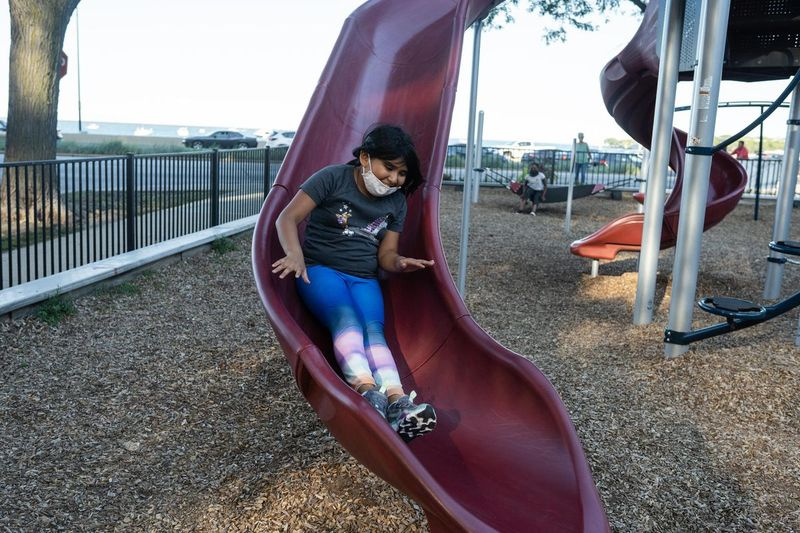 Celeste Hernandez, de 8 años, estudiante del Franklin Fine Arts Center, se desliza por un tobogán en Lake Shore Park Playground en el vecindario de Gold Coast, el 15 de septiembre de 2021.