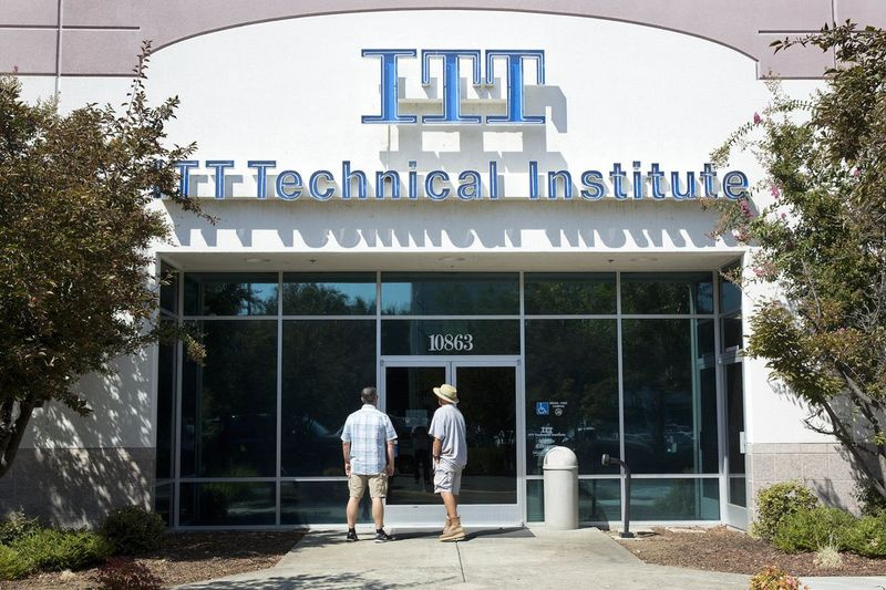 Studentai randa užrakintas duris į ITT technikos instituto miestelį Rančo Kordovoje, Kalifornijoje.