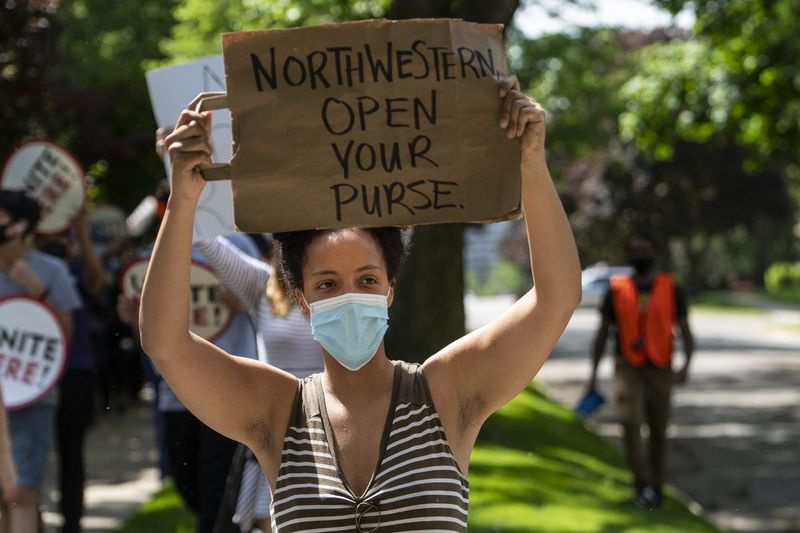 Unas pocas docenas de miembros del personal de la Northwestern University marchan por Evanston exigiendo que la Northwestern University los compense por los salarios que perdieron mientras el campus estaba cerrado en medio de la pandemia de coronavirus, el miércoles 10 de junio de 2020.