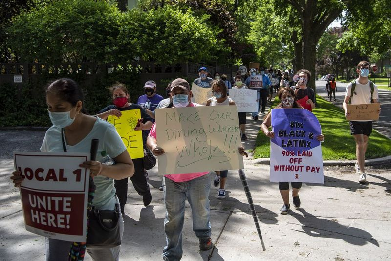 El personal de la Universidad Northwestern marcha por Evanston exigiendo que la escuela los compense por los salarios que perdieron mientras el campus estaba cerrado en medio de la pandemia de coronavirus.