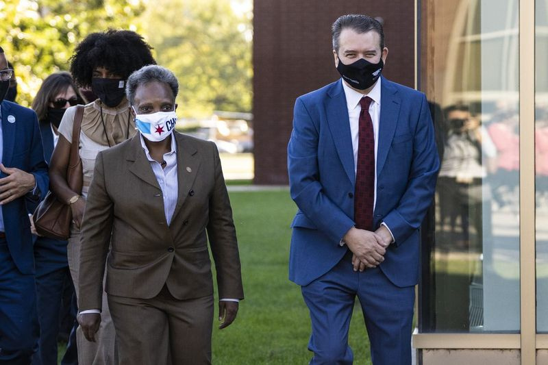 Burgemeester Lori Lightfoot en San Antonio scholen Hoofdinspecteur Pedro Martinez nadert het podium om Martinez aan te kondigen als de nieuwe chief executive van de Chicago Public Schools tijdens een persconferentie buiten de Benito Juarez High School aan de zuidwestkant van Chicago op woensdagochtend 15 september 2021 .
