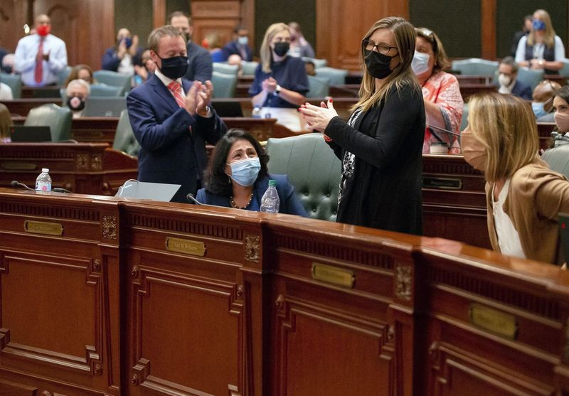 Reprezentantka stanowa Lisa Hernandez, D-Cicero, w centrum, otrzymuje owację na stojąco po przyjęciu propozycji legislacyjnych map stanu Illinois na sali obrad we wtorek wieczorem.