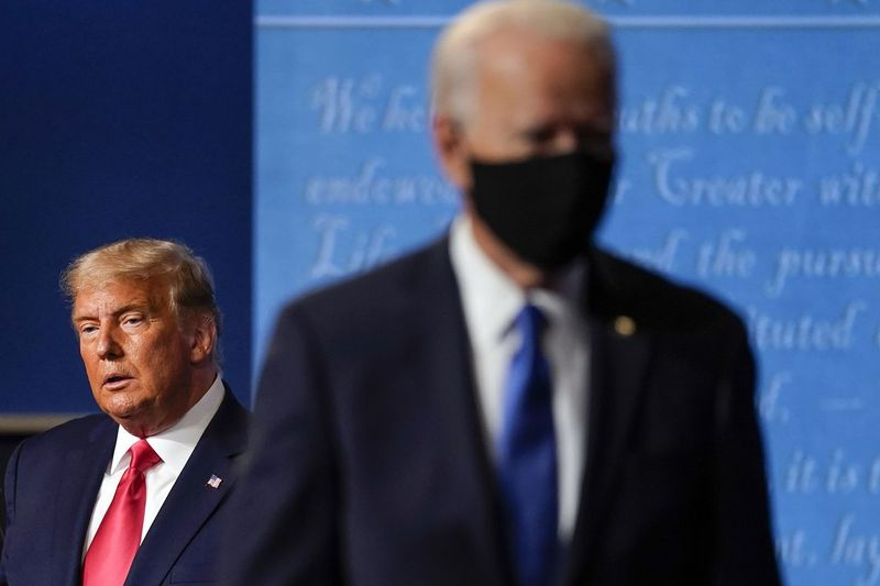 President Donald Trump, til venstre, forblir på scenen mens den daværende demokratiske presidentkandidaten tidligere visepresident Joe Biden, til høyre, går bort torsdag 22. oktober 2020 ved Belmont University i Nashville, Tenn.