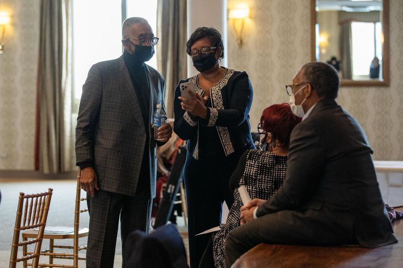 USA:s representant Bobby Rush tittar på Ald. Michelle Harris (8:e) telefon innan en presskonferens förra veckan.