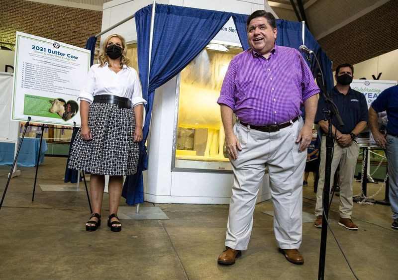 Guvernør JB Pritzker og førstedame MK Pritzker, til venstre, afslører 2021 Butter Cow på Illinois State Fairgrounds på onsdag.