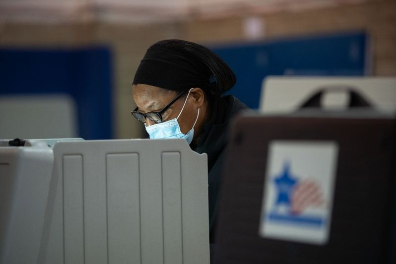 Un elettore vota il giorno delle elezioni alla Stone Scholastic Academy nel West Rogers Park.