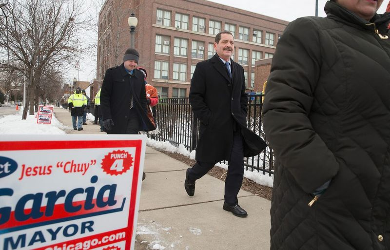O então candidato a prefeito de Chicago, Jesus Chuy Garcia, no centro, deixa uma seção eleitoral após votar em 2015.