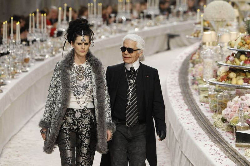 På dette arkivbildet fra 2011 erkjenner den tyske motedesigneren Karl Lagerfeld med den britiske modellen Stella Tennant applaus på slutten av presentasjonen av hans Paris-Bombay-kolleksjon for Chanel, presentert på Grand Palais i Paris.