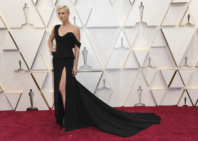 Charlize Theron arrive dimanche soir aux Oscars en tenue Dior Haute Couture.