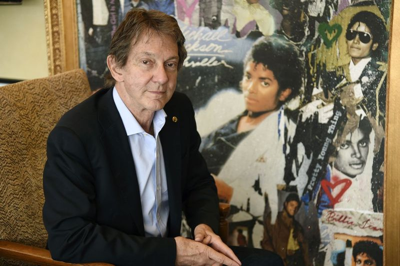 På dette bildet tirsdag 18. juni 2019 poserer underholdnings- og selskapsadvokat John Branca, medeksekutor av Michael Jacksons eiendom, på kontoret sitt ved siden av et kunstverk som ble presentert for ham fra Sony Music til minne om salget av 100 millioner eksemplarer av Mich