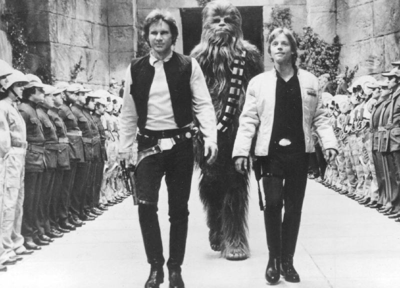 Harrisonas Fordas (iš kairės) kaip Hanas Solo, Peteris Mayhew kaip Chewbacca ir Markas Hamilas kaip Luke