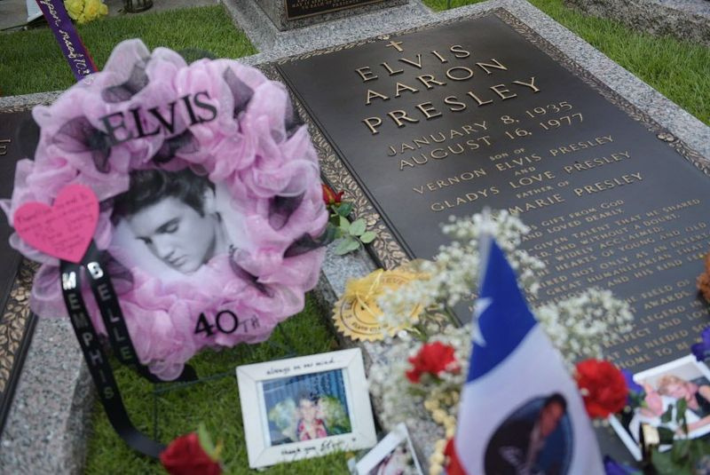 Pagarbos ir atminimo dovanėlės matomos šalia Elvio Presley kapo ženklo Meditacijos sode, kur jis 2017 m. rugpjūčio 12 d. Memfyje, Tenesio valstijoje, palaidotas kartu su tėvais ir močiute savo Gracelando dvare. | MANDEL NGAN/AFP/Getty Images
