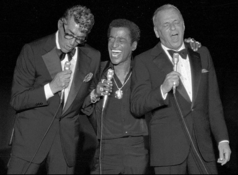 Frank Sinatra canta junto con sus compañeros miembros de Rat Pack Dean Martin y Sammy Davis Jr., en una reunión de recaudación de fondos en Santa Mónica, California, el 22 de mayo de 1978, en beneficio de una organización benéfica. | Foto / Archivo AP