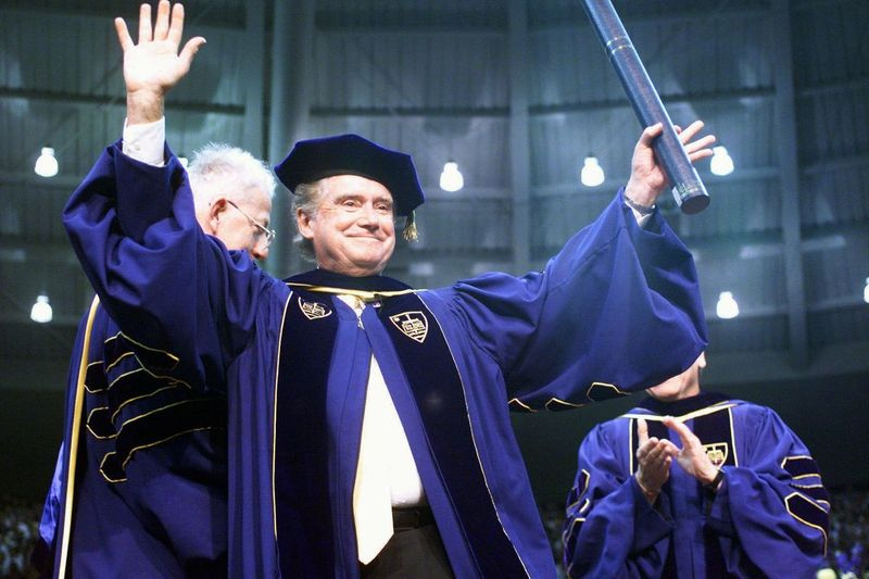 Regis Philbin, um ex-aluno da Notre Dame, acena para a multidão após receber um título honorário durante os 154 anos de formatura da Notre Dame em South Bend, Indiana, em 1999.