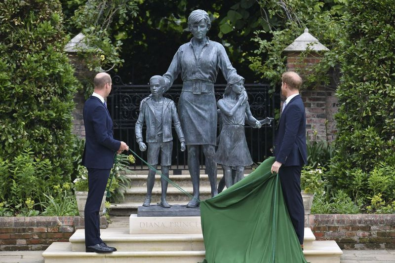 Storbritanniens prins William (till vänster) och prins Harry avtäcker en staty som de beställde av sin mamma prinsessan Diana, på vad som skulle ha varit hennes 60-årsdag, i Sunken Garden på Kensington Palace, London, på torsdagen.