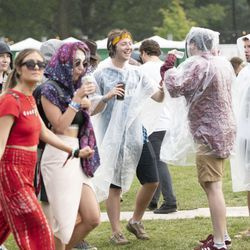 Festivalbesökare tar på sig regnkläder. | Colin Boyle/Sun-Times