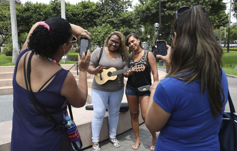 Fännid, kes märkasid Venezuela lauljat Reymar Perdomot Peruus Limas pargis, poseerivad temaga koos fotodel. | AP