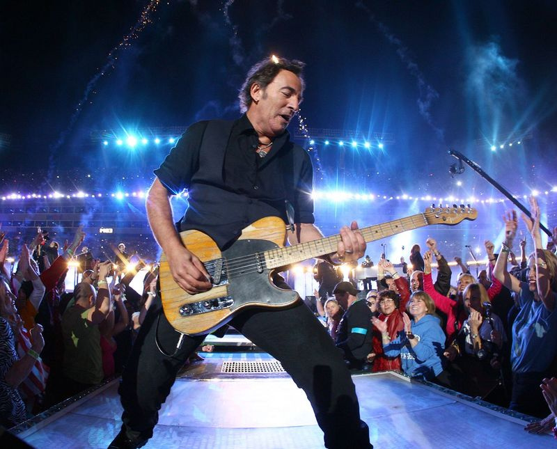 Sukarelawan peminat bersorak pada Bruce Springsteen semasa persembahan Super Bowl 2009 beliau.