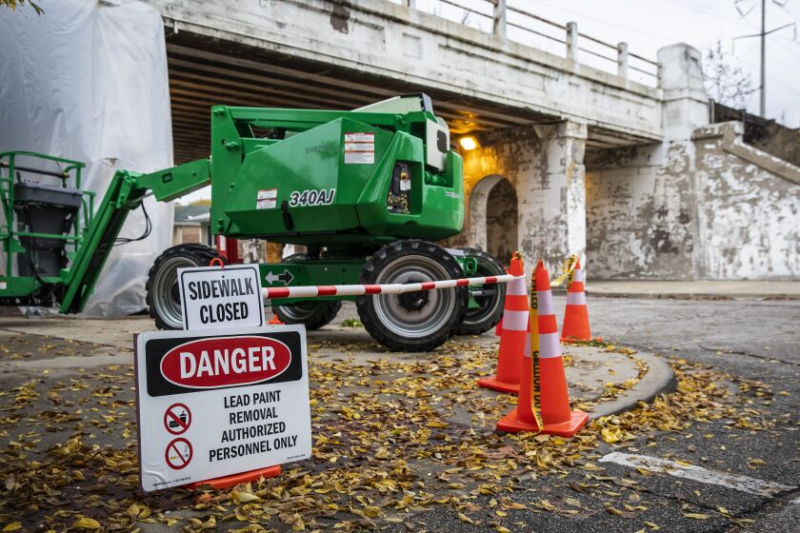   Le trottoir est fermé et l'équipement d'une équipe de travail se trouve sur un viaduc sur la 64e rue ouest à South Central Park Avenue, où la peinture au plomb s'écaillait dans le passage du viaduc du côté sud-ouest, mercredi après-midi 12 octobre 2022.