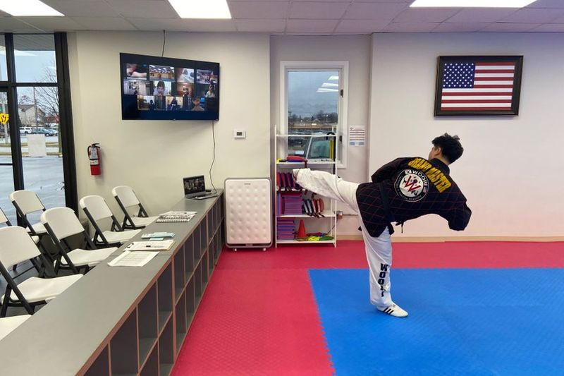 Ο Grandmaster Kwan Pil Kim του Woori Taekwondo & Hapkido επιδεικνύει μια κλωτσιά στους μαθητές του που κοιτάζουν από τις ψηφιακές συσκευές τους κατά τη διάρκεια της παραγγελίας του Illinois για παραμονή στο σπίτι.