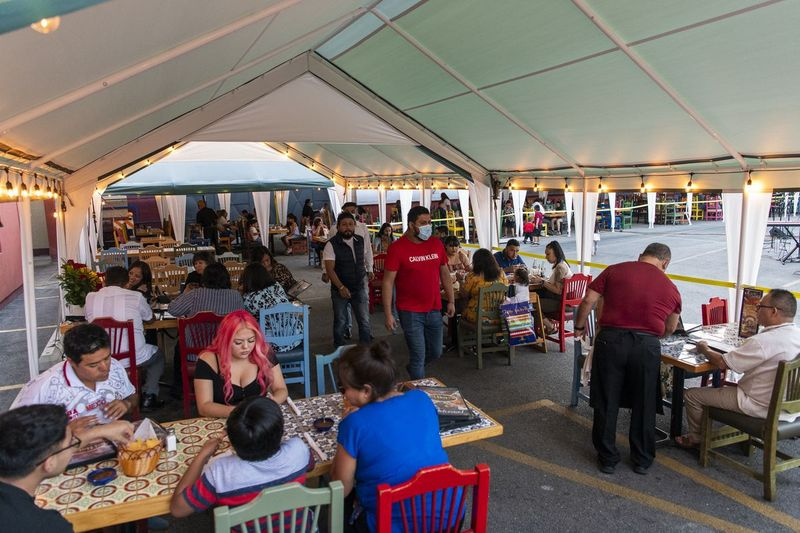 Les gens dînent sur le patio extérieur de Mi Tierra. Comme de nombreux restaurants touchés par la pandémie, il a converti son parking en espace de restauration extérieur pour tenter d