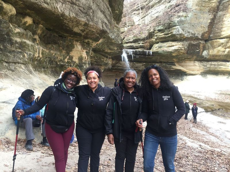 Quattro persone in piedi insieme davanti a un canyon/cascata