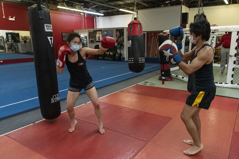 Jun Phan (til venstre), en student ved EKF Martial Arts sparrer med eier og hovedtrener Tony Marquez under en boksetime i juni. Mens gruppetimer ikke lenger tilbys under nye statlige restriksjoner, er en-til-en-timer fortsatt tillatt i treningssentre.