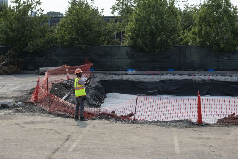 En bygningsarbeider tar bilder av byggeplassen for Walmart Academy som ligger ved parkeringsplassen til Walmart, som ligger på 8331 S. Stewart Ave. i Chatham-området, mandag 19. juli 2021.