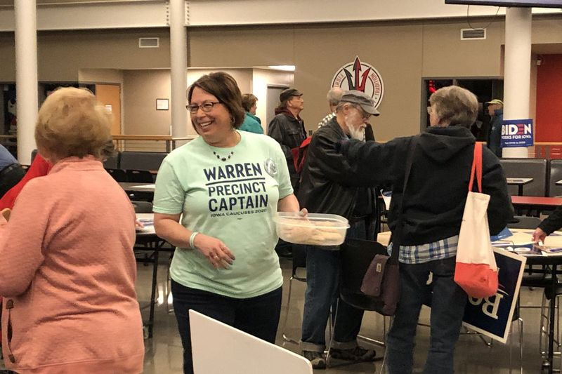 Julie Raab, capitã de distrito de Elizabeth Warren, circula pela Clinton Middle School em Clinton, Iowa. Raab não conseguiu reunir votos suficientes para conseguir delegados - mas ela tinha mais compradores para seus biscoitos caseiros.