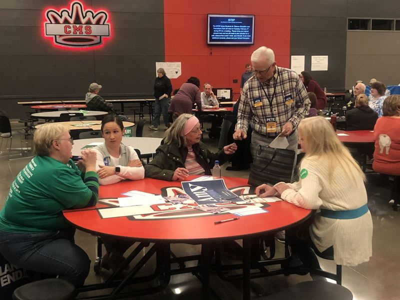 Larry Fogg, participante da convenção política pela primeira vez, entrega um adesivo de Pete Buttigieg a um apoiador de Amy Klobuchar em seus esforços para obter o apoio dela na Clinton Middle School em Clinton, Iowa.