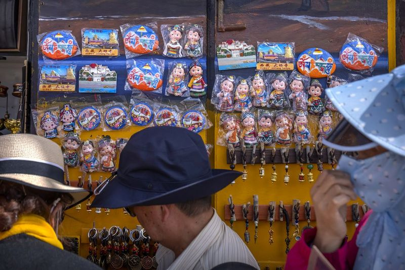 Turister ser på varer for salg i en suvenirbutikk utenfor Jokhang-tempelet i Lhasa i den vestlige Kinas autonome region Tibet.