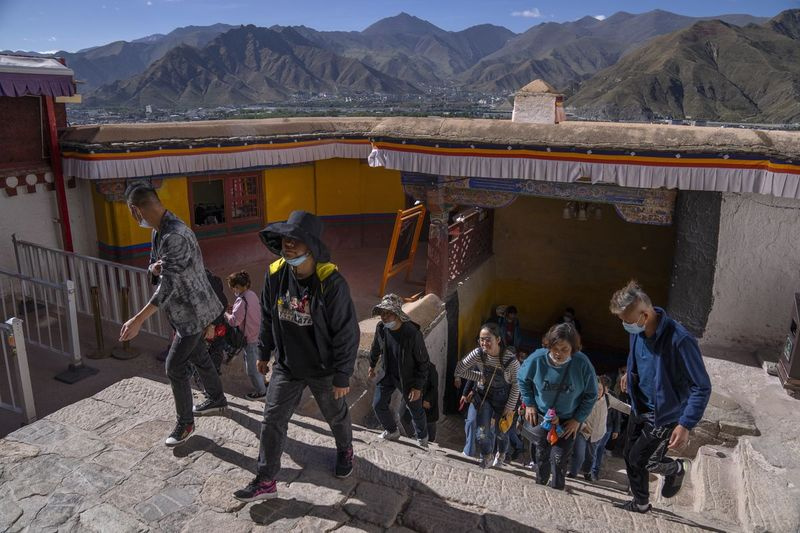 Turister går opp en trapp ved Potala-palasset i Lhasa i den vestlige Kinas autonome region Tibet.