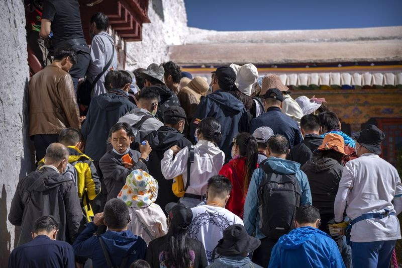 Turister venter med å klatre opp trapper til et indre område ved Potala-palasset i Lhasa i den vestlige Kinas autonome region Tibet.