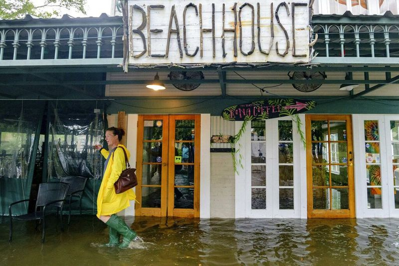 Aimee Cutter loopt door het water voor haar restaurant in Mandeville, Louisiana