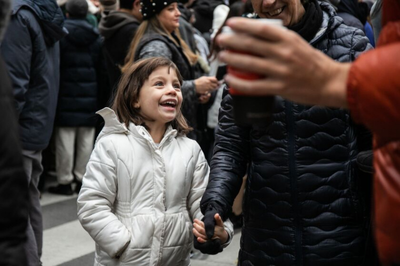   Julieta Vincentelli, 6, gav sin far en pause fra at sidde på sine skuldre og smilede, mens hun gik på West Washington Street nær North State Street under Thanksgiving Day-paraden. Hun er hendes familie, der besøger Chicago fra Memphis.