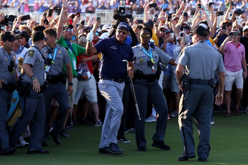 Phil Mickelson gibt einen Daumen hoch, als er während der letzten Runde der PGA Championship im Ocean Course des Kiawah Island (S.C.) Golf Resort am Sonntag von Sicherheitskräften auf seinem Spaziergang auf dem 18. Fairway unterstützt wird.