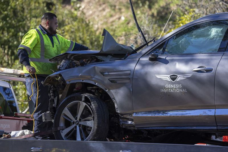 Ein Schild für das Genesis Invitational-Golfturnier ist an der Tür des Autos zu sehen, das Golflegende Tiger Woods fuhr, als er am 23. Februar in Rolling Hills Estates, Kalifornien, bei einem Überschlag schwer verletzt wurde. Retter benutzten hydraulische Rettungsgeräte, um ihn zu befreien .