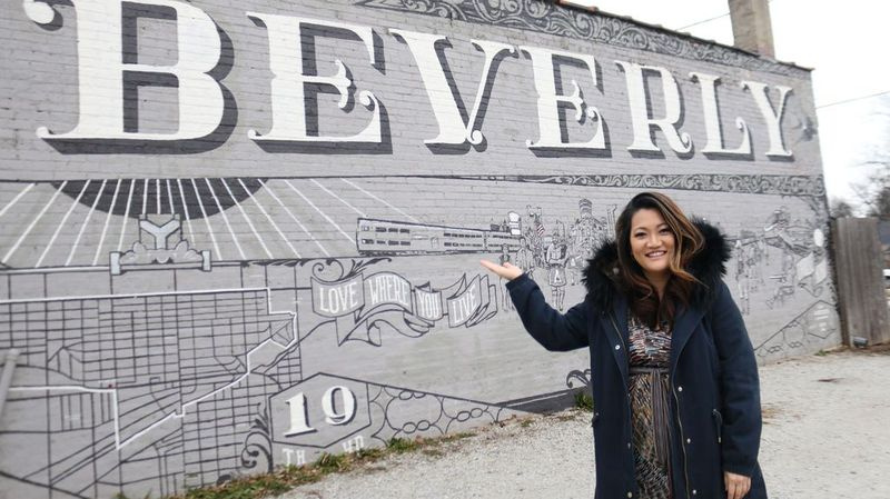Ji Suk Yi di hadapan mural Beverly dengan moto kejiranan, Cintai tempat tinggal anda. | Brian Rich/For the Sun-Times