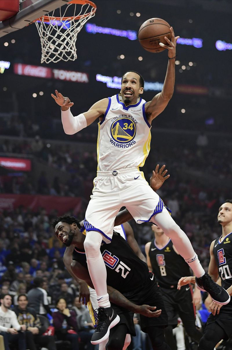 „Golden State Warriors“ gynėjas Shaunas Livingstonas pataikė, kai Los Andželo „Clippers“ gynėjas Patrickas Beverley kairėje gynėsi per pirmąjį NBA krepšinio atkrintamųjų varžybų serijos šeštą kėlinį Los Andžele.