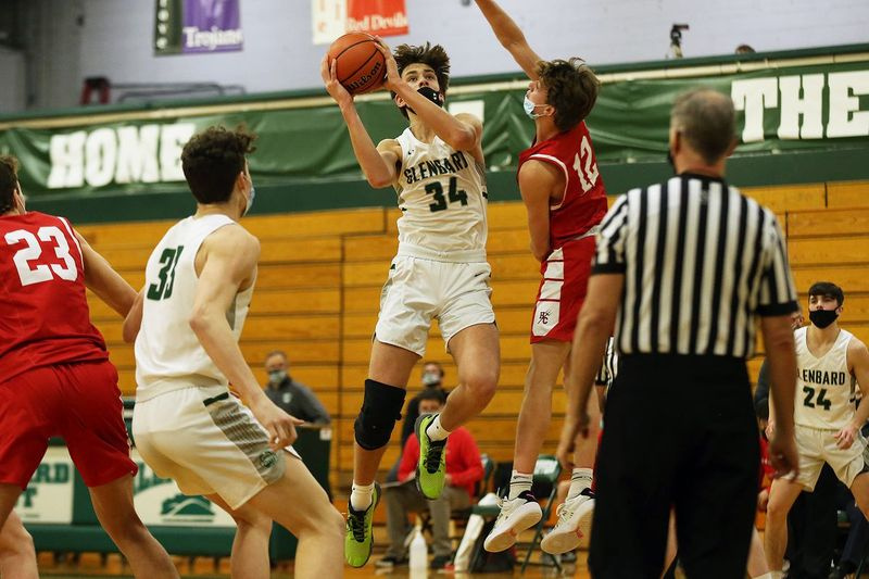 Braden Huff (34 ans) de Glenbard West passe le ballon dans sa main droite pour un tir contre Hinsdale Central.