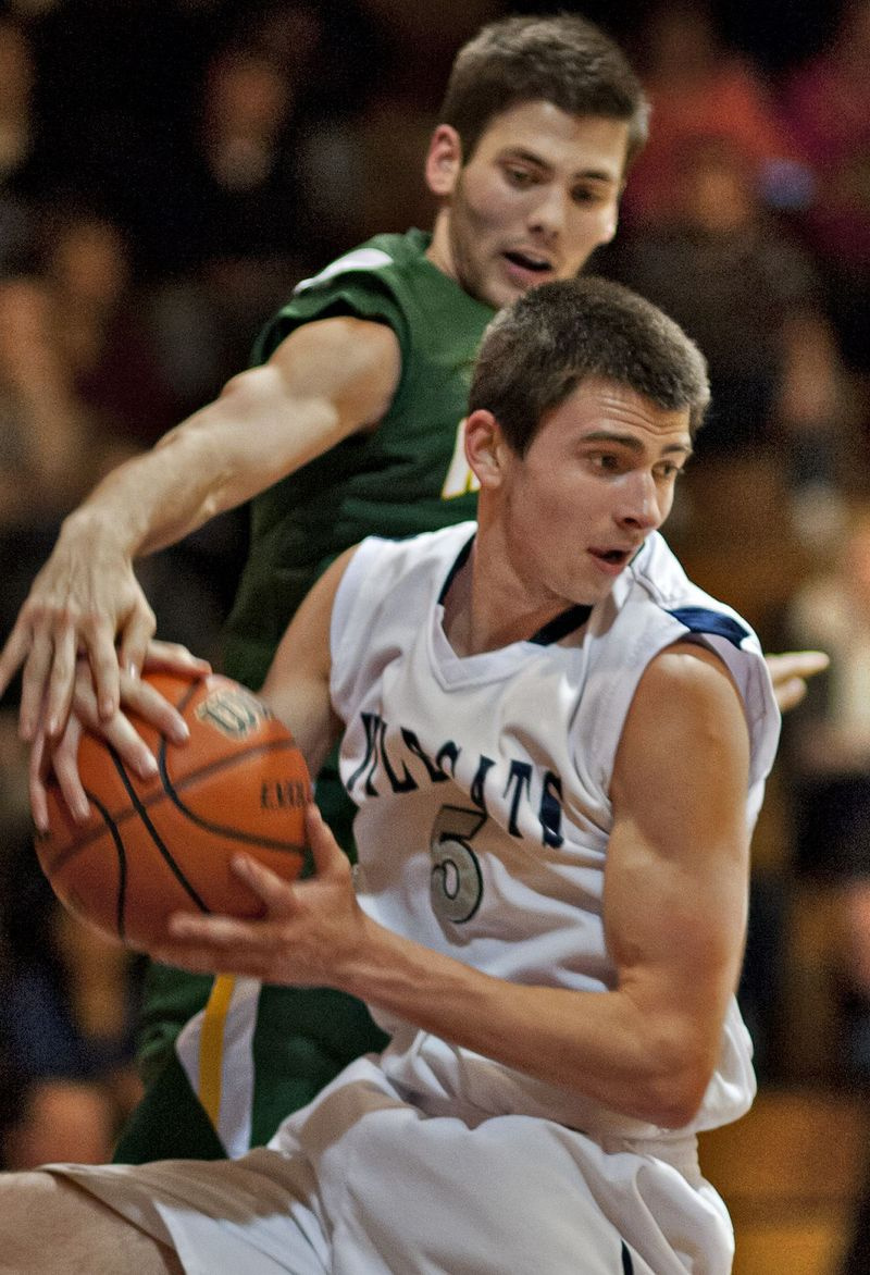 John Konchar (5) uit West Chicago komt neer met een rebound die net buiten bereik is van Matt Gialamas van Waubonsie Valley.